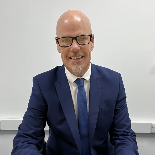Mr Iain Addison sat at his desk.